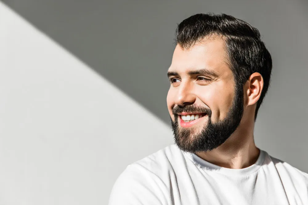Smiling bearded male patients after receiving dental bridges in Boca Raton. 