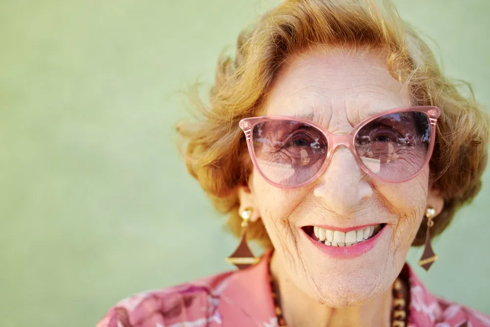 Elderly woman smiling after receiving dentures in Boca Raton. 