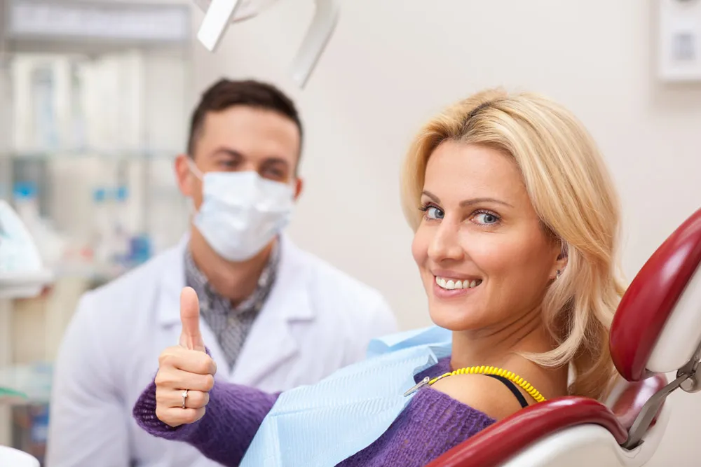 Young woman giving a thumbs up before oral surgery in Boca Raton. 
