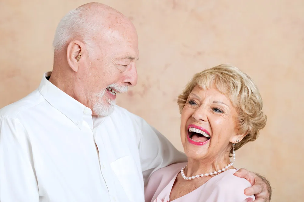 Elderly couple laughing after receiving restorative dentistry in Boca Raton. 