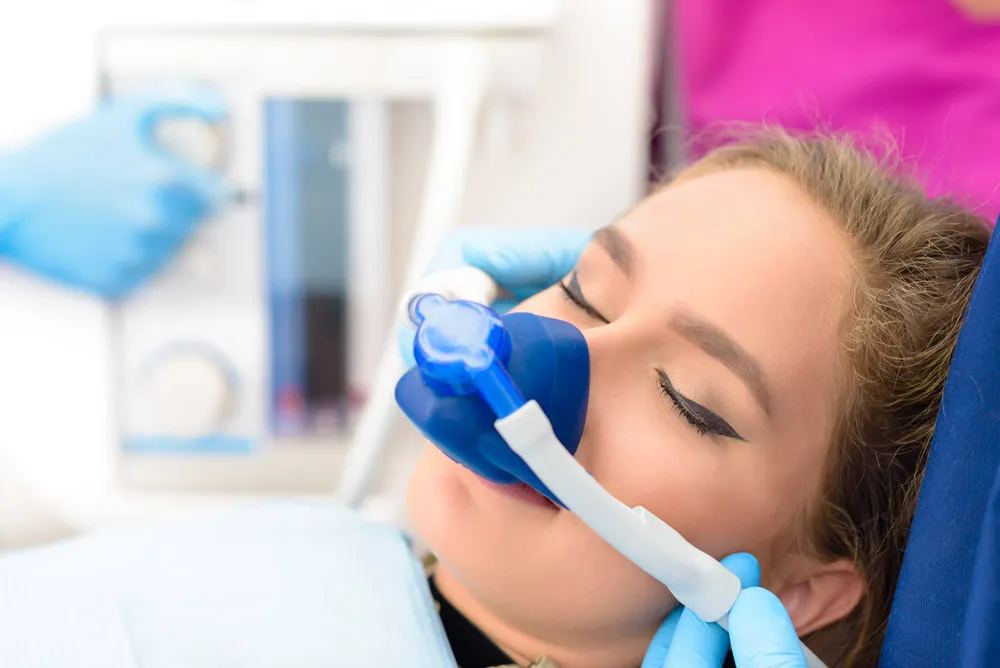 Patient sleeping with an oxygen mask under the effects of sedation dentistry in Boca Raton. 