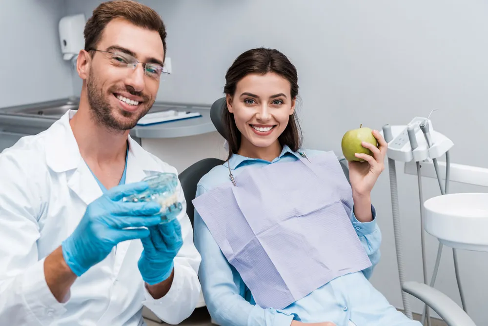 Doctor explaining dentures in Boca Raton to a smiling patient. 