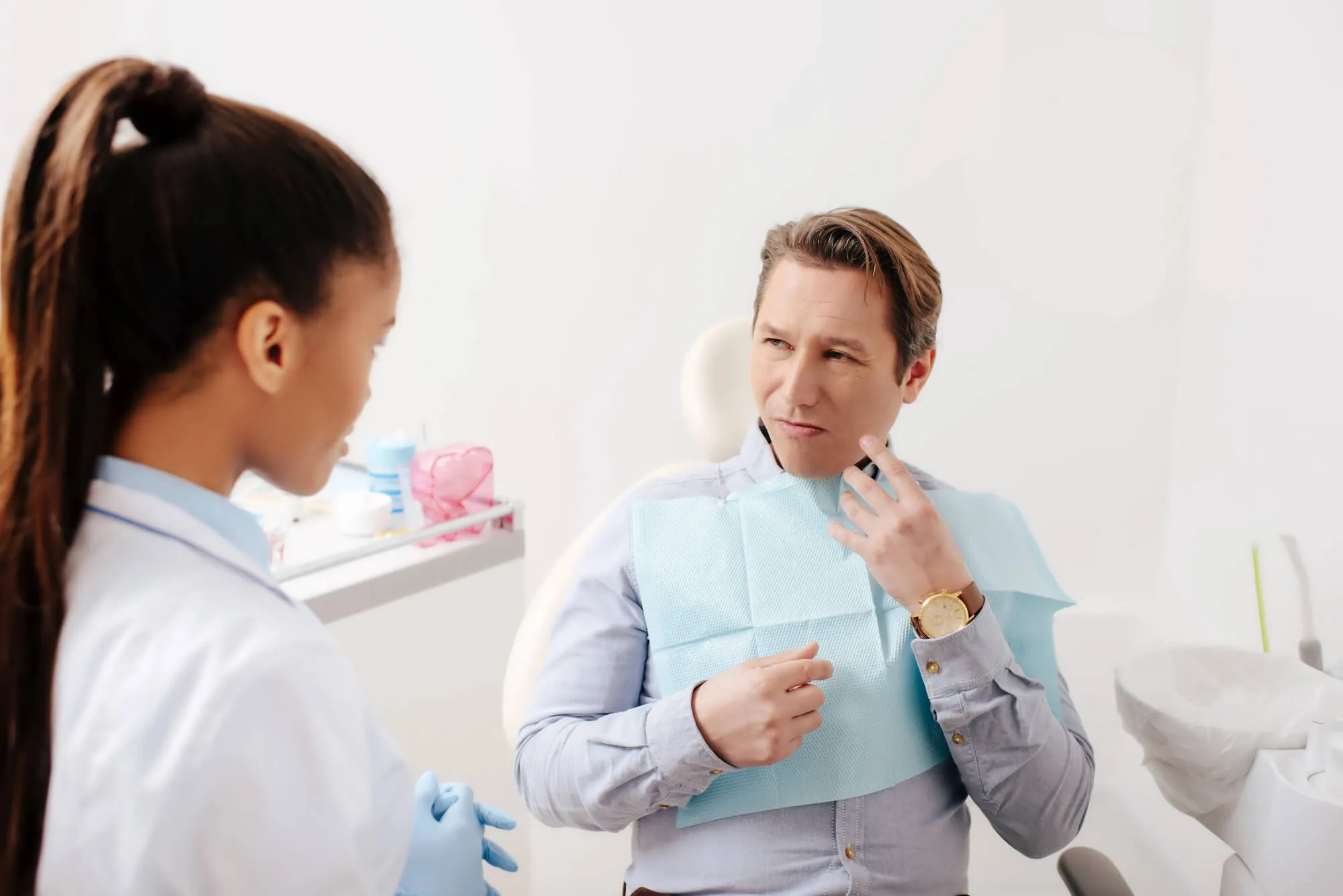 patient explaining the pain he feels to his emergency dentist boca raton