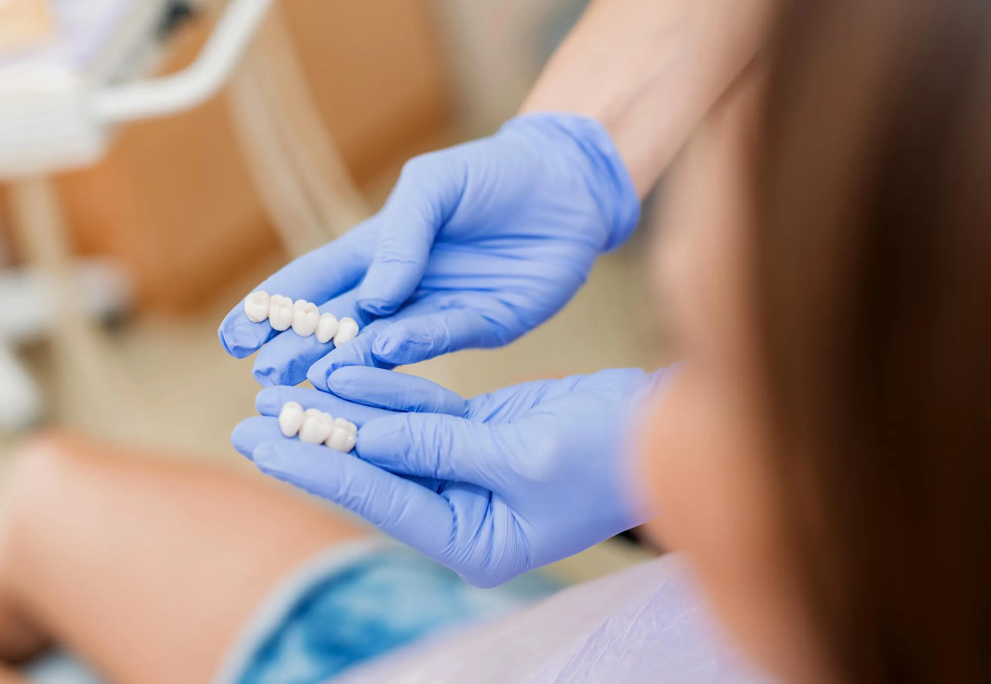 dentist showing patient a sample of crowns boca raton